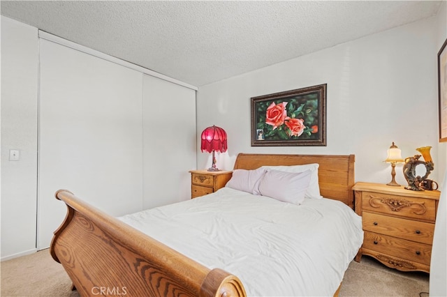 bedroom featuring a textured ceiling and light colored carpet