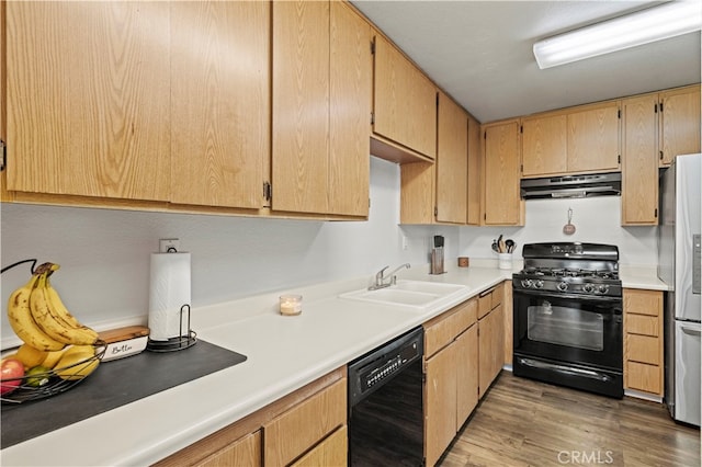 kitchen featuring light brown cabinets, hardwood / wood-style flooring, sink, and black appliances