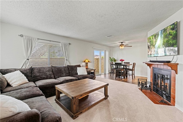 living room with a textured ceiling, ceiling fan, and hardwood / wood-style flooring