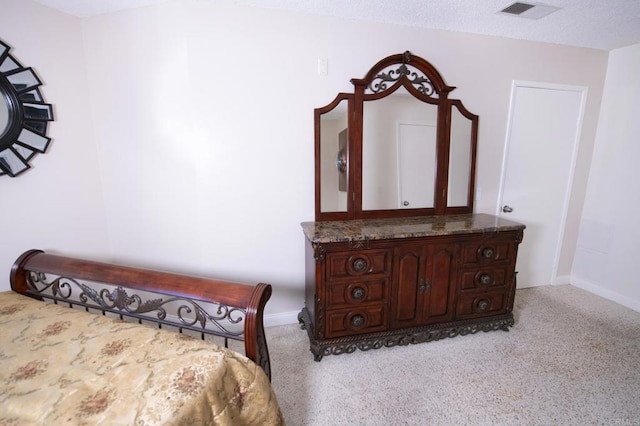 bedroom featuring light carpet and a textured ceiling