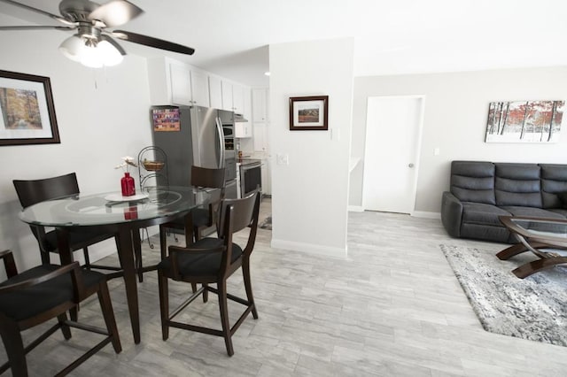 dining space featuring ceiling fan and light wood-type flooring