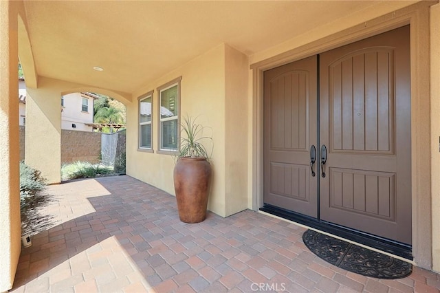 property entrance featuring a patio and stucco siding