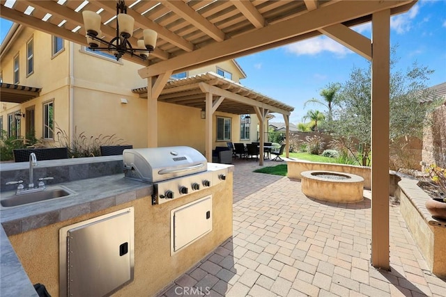 view of patio / terrace with a sink, a fire pit, area for grilling, and fence