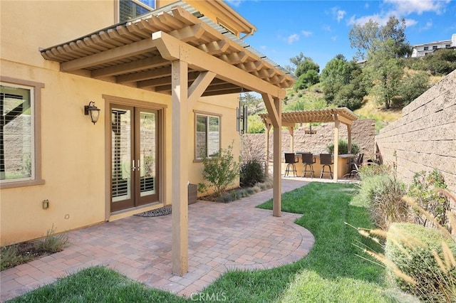 view of patio featuring french doors, fence, outdoor dry bar, and a pergola