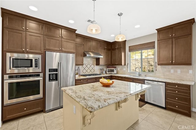 kitchen featuring visible vents, a sink, decorative backsplash, stainless steel appliances, and under cabinet range hood