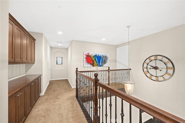 hallway with recessed lighting, baseboards, light carpet, and an upstairs landing