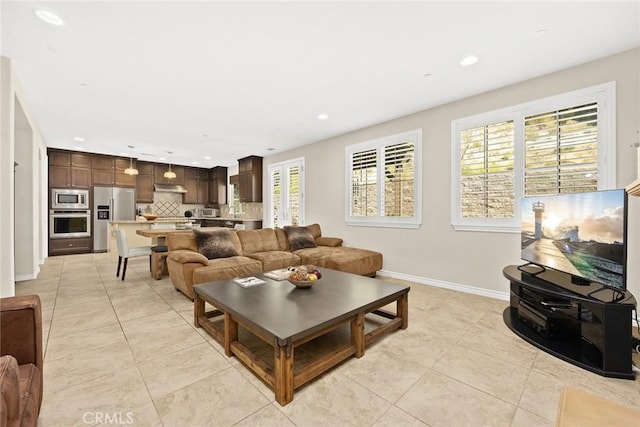 living area featuring light tile patterned flooring, recessed lighting, and baseboards