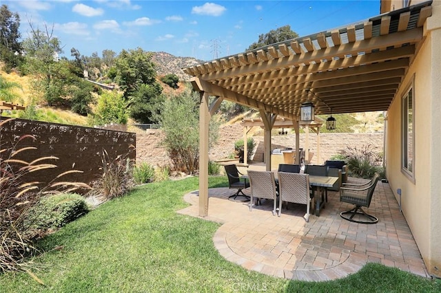 view of patio featuring a mountain view, a pergola, outdoor dining area, and a fenced backyard