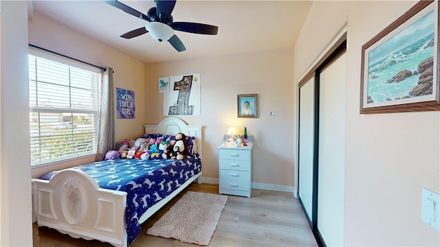 bedroom with ceiling fan, light hardwood / wood-style floors, and a closet