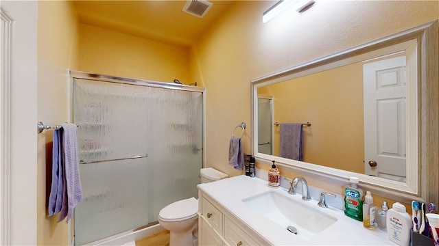 bathroom featuring vanity, toilet, and an enclosed shower