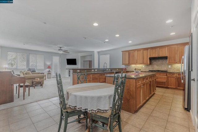 kitchen with tasteful backsplash, light tile patterned floors, stainless steel appliances, ceiling fan, and sink