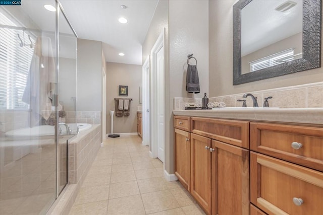 bathroom featuring independent shower and bath, vanity, and tile patterned floors