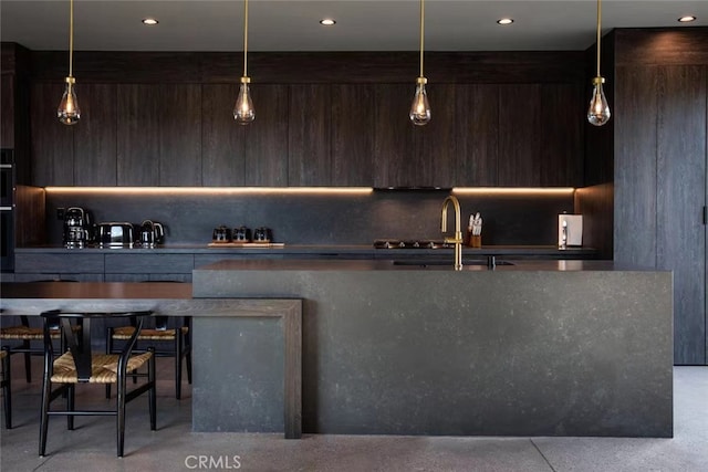 bar featuring dark brown cabinets, sink, and pendant lighting