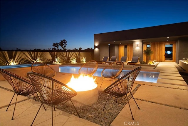 view of swimming pool with an outdoor fire pit and a patio area