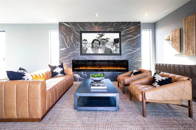 carpeted cinema featuring tile walls, a fireplace, and plenty of natural light