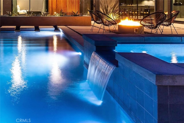 view of swimming pool featuring a patio and pool water feature