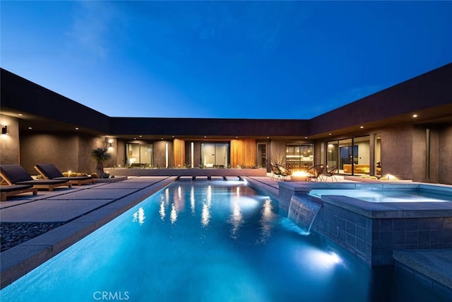 view of pool with an in ground hot tub, pool water feature, and a patio area