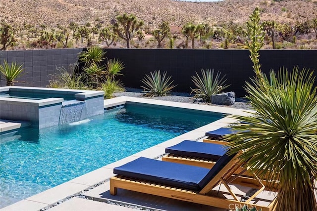 view of swimming pool featuring an in ground hot tub and pool water feature