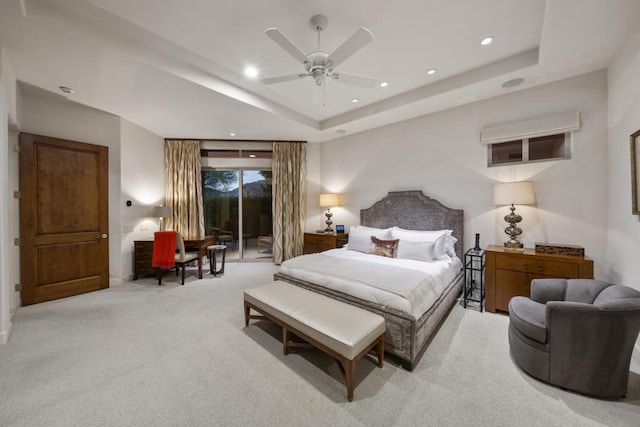 bedroom with ceiling fan, access to exterior, light carpet, and a tray ceiling