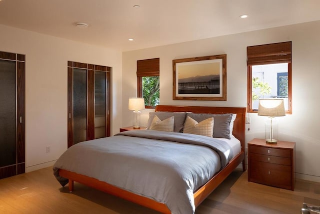 bedroom with hardwood / wood-style floors and multiple windows