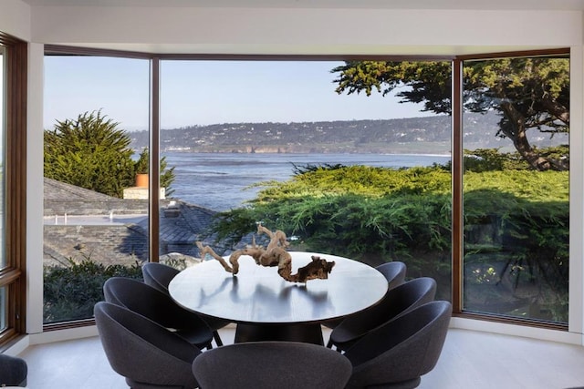 sunroom featuring a water view