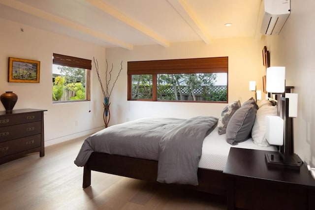 bedroom with beamed ceiling, light hardwood / wood-style floors, a wall unit AC, and multiple windows