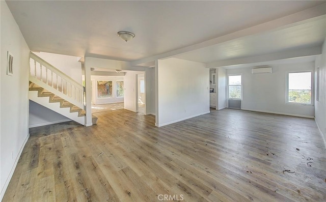 572 Church Hill Rd, La Habra Heights, CA 90631 - unfurnished living room with an AC wall unit, stairway, and wood finished floors