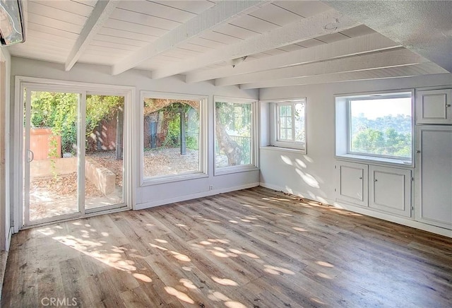 unfurnished sunroom with beam ceiling