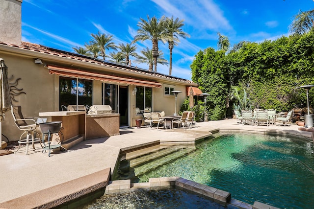 view of pool with a patio, a hot tub, and exterior kitchen