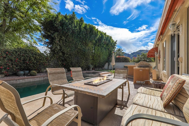 view of patio with a mountain view and a fire pit