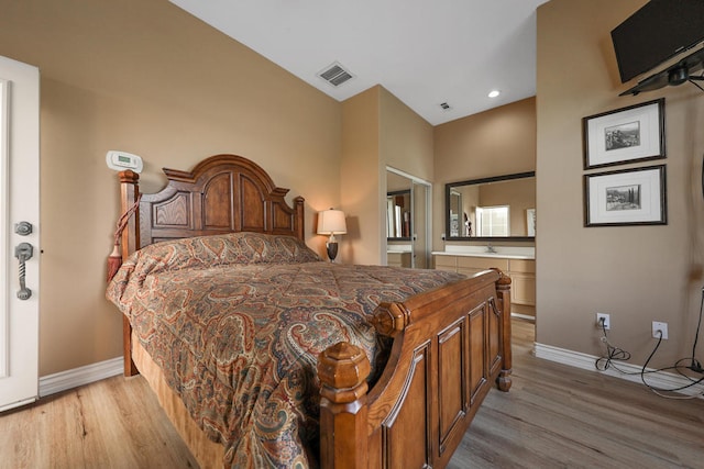 bedroom featuring ensuite bathroom and light hardwood / wood-style floors