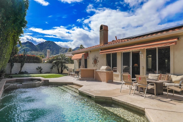 exterior space featuring a mountain view, a pool with hot tub, and a patio