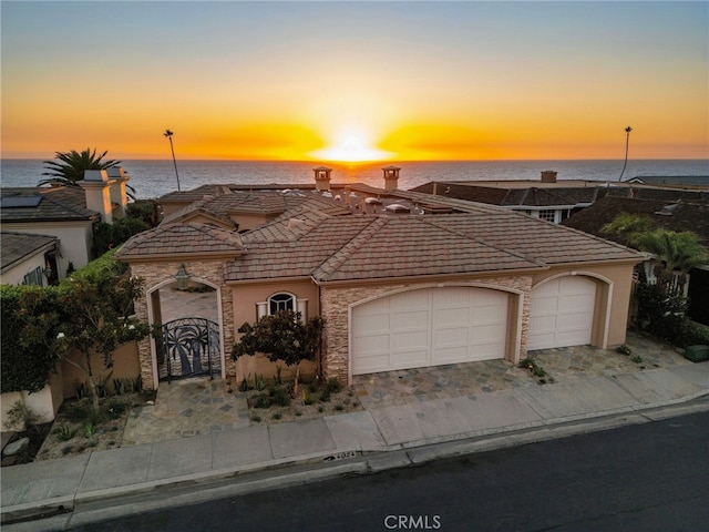 view of front facade with a water view and a garage