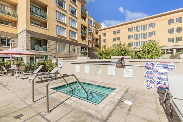 view of swimming pool with a community hot tub and a patio area