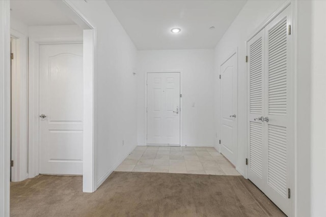 hallway featuring light colored carpet