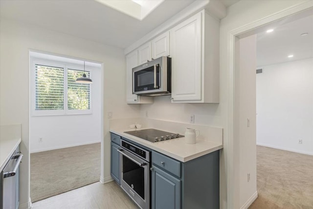 kitchen featuring light colored carpet, white cabinetry, and stainless steel appliances