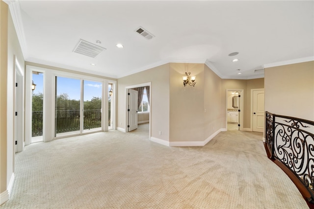 carpeted spare room featuring crown molding and a chandelier