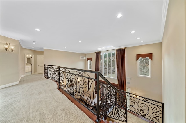 corridor with ornamental molding, light colored carpet, and an inviting chandelier