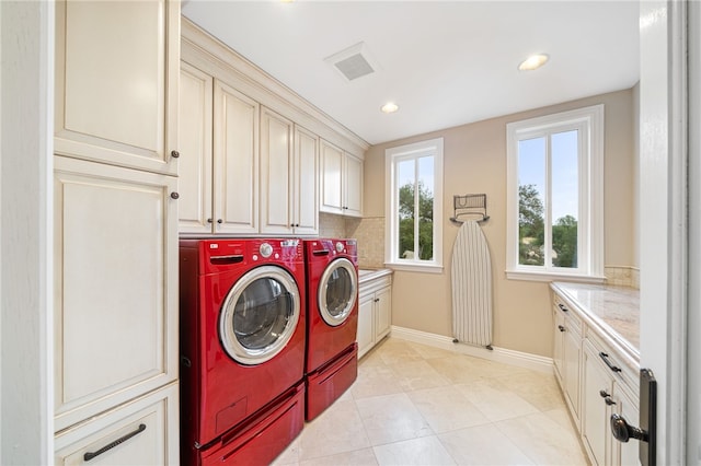 washroom with separate washer and dryer, cabinets, and light tile patterned floors