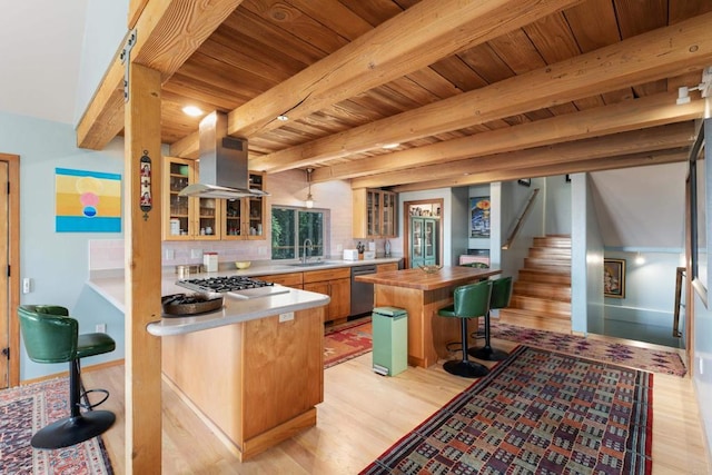 kitchen featuring appliances with stainless steel finishes, a kitchen island, beamed ceiling, sink, and island range hood