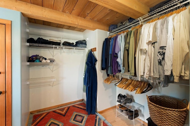 walk in closet featuring hardwood / wood-style flooring and beam ceiling