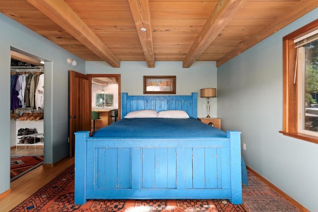 bedroom with wood-type flooring, a closet, beamed ceiling, and wooden ceiling