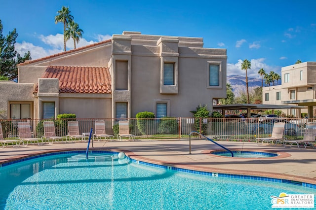 view of swimming pool featuring a community hot tub and a patio