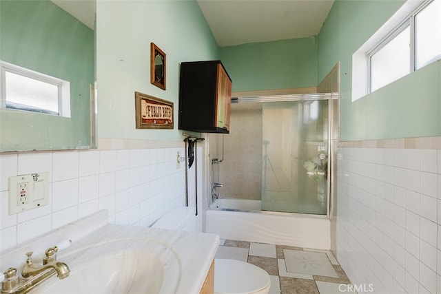 full bathroom with enclosed tub / shower combo, vanity, toilet, and a healthy amount of sunlight