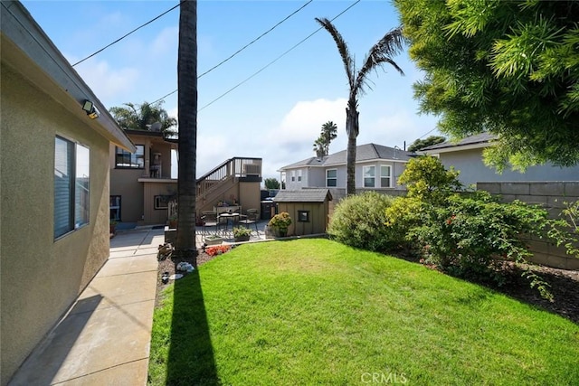 view of yard featuring a patio area and a storage shed