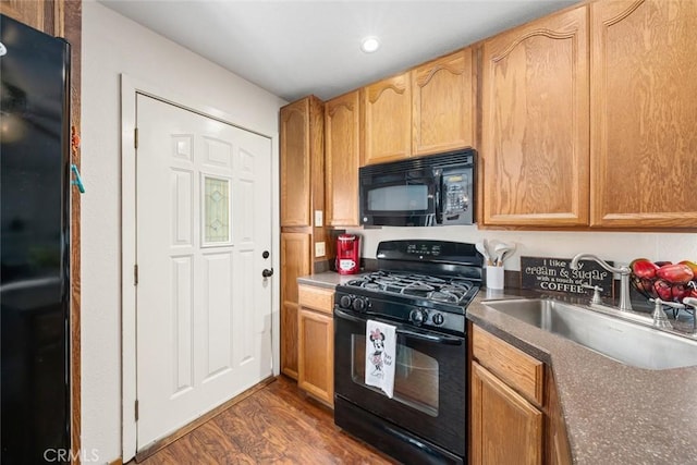 kitchen featuring sink, dark hardwood / wood-style flooring, and black appliances