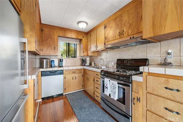 kitchen featuring stainless steel appliances, sink, and decorative backsplash