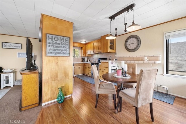 dining area featuring crown molding and light hardwood / wood-style flooring
