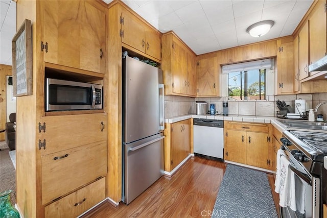 kitchen featuring stainless steel appliances, dark hardwood / wood-style flooring, sink, and decorative backsplash