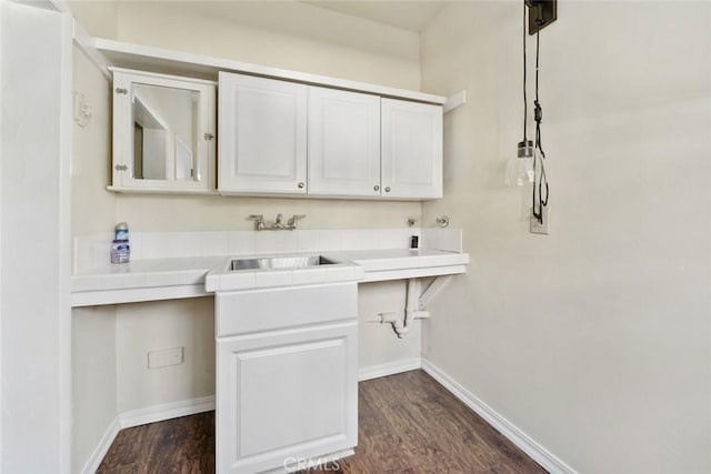 laundry room featuring dark hardwood / wood-style floors and sink